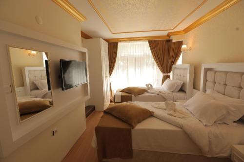 Habitación de hotel con 2 camas y espejo en GARDEN OTEL AMASYA, en Amasya
