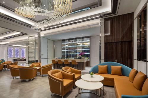 a lobby with couches and tables and a bar at Wyndham Shaoxing Keqiao in Shaoxing