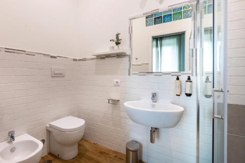 biała łazienka z umywalką i toaletą w obiekcie Colosseo Road w Rzymie