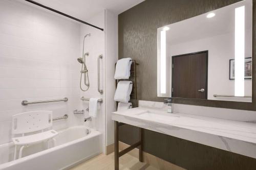 a bathroom with a sink and a tub and a mirror at La Quinta Inn & Suites by Wyndham Denver Parker in Parker