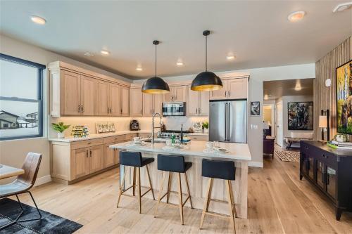 a kitchen with wooden cabinets and a large island with bar stools at Helling Circle Secret 102 condo in Heber City