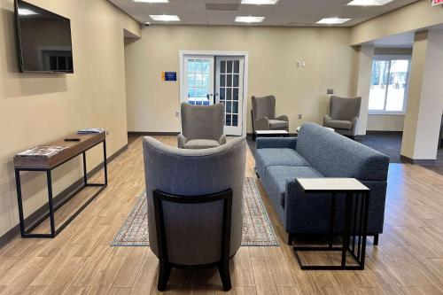 a waiting room with a couch and a table and chairs at Days Inn by Wyndham Monroe NC in Monroe