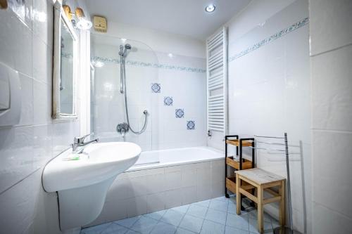 een witte badkamer met een wastafel en een bad bij Appartamento Con Giardino in Florence