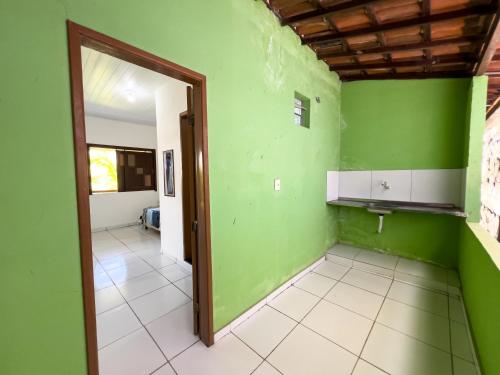 een lege kamer met groene muren en een deuropening bij Pousada Praia da Cueira in Cayru