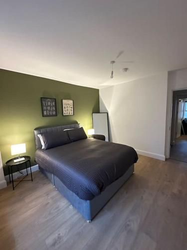 a bedroom with a bed and a green wall at Convenient & Central Apartment in Dublin