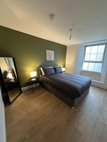 a bedroom with a bed and a green wall at Convenient & Central Apartment in Dublin