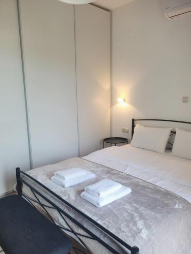a bedroom with a bed with two towels on it at Villa THAMI in Almirida