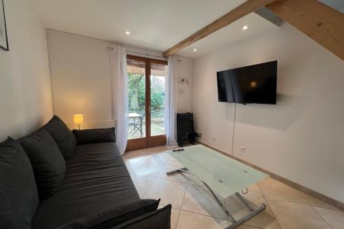 sala de estar con sofá y TV en la pared en Clos Briard - Duplex 4 people near Disneyland, en La Houssaye-en-Brie