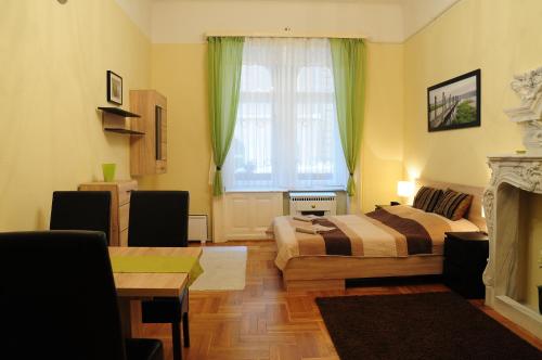 ブダペストにあるGreen Apple Apartmanのベッドルーム1室(ベッド1台、テーブル、窓付)