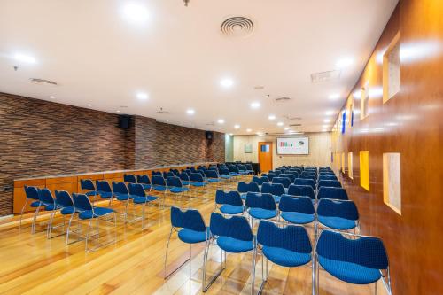 a conference room with blue chairs and a wall at Hotel Castellon Center Affiliated by Meliá in Castellón de la Plana