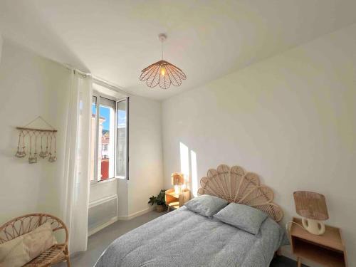 une chambre avec un lit, une fenêtre et un lustre dans l'établissement « Le Sun » logement cosy, 4 pers gare de Hyères, à Hyères