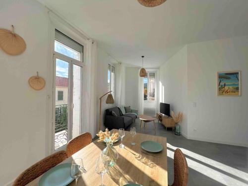 un salon avec une table et des chaises en bois dans l'établissement « Le Sun » logement cosy, 4 pers gare de Hyères, à Hyères