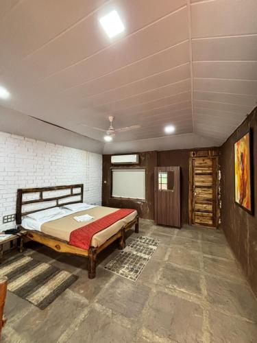 ein Schlafzimmer mit einem Bett in einem Zimmer in der Unterkunft Wild Woods Tiger Resort in Nagpur