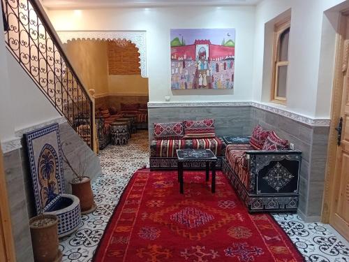 ein Wohnzimmer mit einem Sofa und einer Treppe in der Unterkunft Riad Rayan in Marrakesch