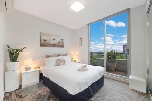 a bedroom with a bed and a large window at Lovely home with pool in Zetland in Sydney