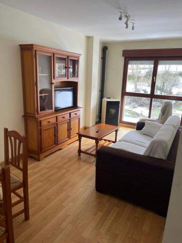 uma sala de estar com um sofá e uma televisão em Apartamentos Fele2 em Felechosa