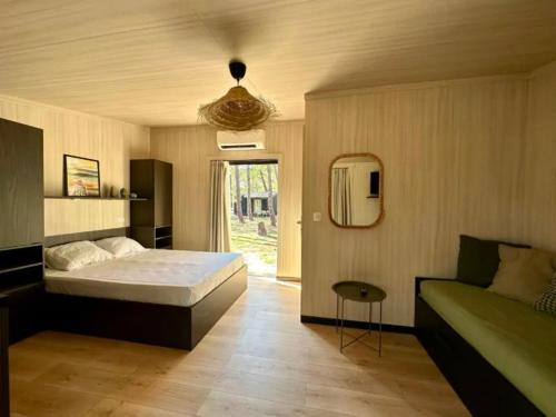 een slaapkamer met een bed en een bank bij Camping Golfo Di Sogno in Porto-Vecchio