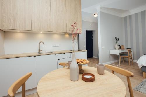 a kitchen and dining room with a table and a sink at Aparthotel Amella in Rīga