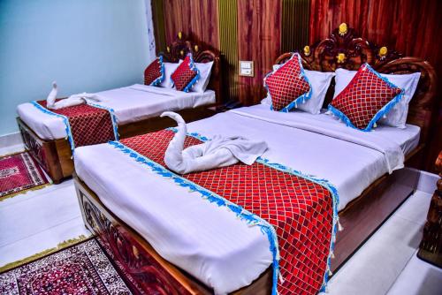 two beds in a room with two swans on them at Hotel Anita in Baripāda