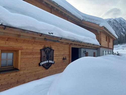 a building covered in snow with a sign on it at Engadin Chalet - Private Spa Retreat & Appart -St Moritz - Val Bever in Bever