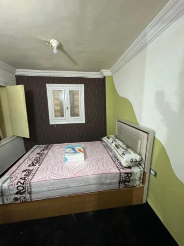 a small bed in a room with a window at شقه صغيره فندقيه في موقع مميز جديده وفرش وموبيليا جديده in Mansoura