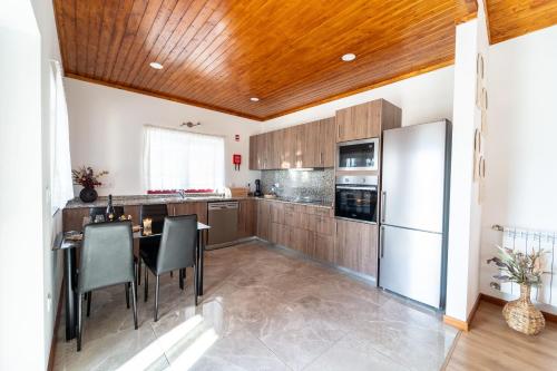 eine Küche mit Tisch und Kühlschrank in der Unterkunft Assento do Cávado by House and People in Valdosende