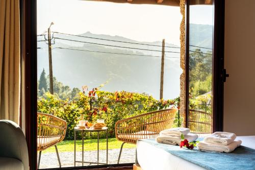 ein Zimmer mit Blick auf eine Terrasse mit Tisch und Stühlen in der Unterkunft Assento do Cávado by House and People in Valdosende