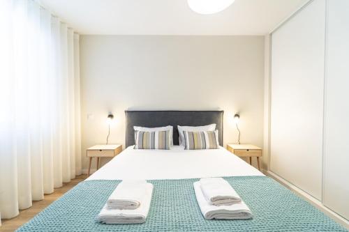 una camera da letto con un letto grande con asciugamani sopra di On The Square Studio - City Center by House and People a Braga