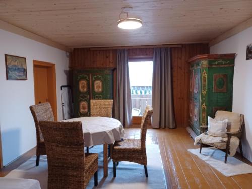 ein Esszimmer mit einem Tisch, Stühlen und einem Fenster in der Unterkunft Lampererhof in Sankt Johann in Tirol