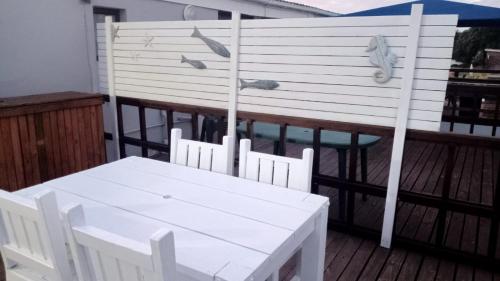 a white table and chairs on a deck at Bellevue Resort Stilbaai Nr.7 in Stilbaai