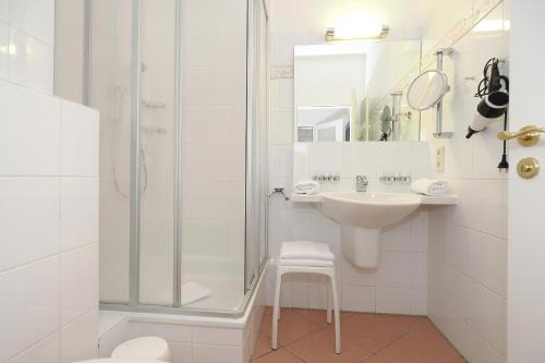 ein weißes Badezimmer mit Waschbecken und Dusche in der Unterkunft Seehof Seehof 24 in Bansin