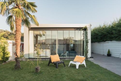 a house with two chairs and a palm tree at Casa Calima in Esteiro