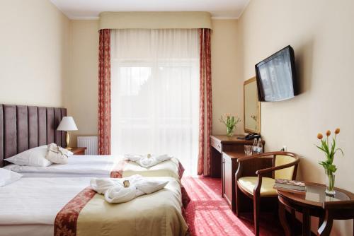 a hotel room with two beds and a window at Lila Medical SPA in Ciechocinek