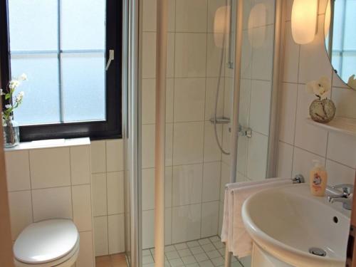 uma casa de banho com um chuveiro, um WC e um lavatório. em Ferienhaus Nr 14, Kategorie Komfort, Feriendorf Hochbergle, Allgäu em Bichel