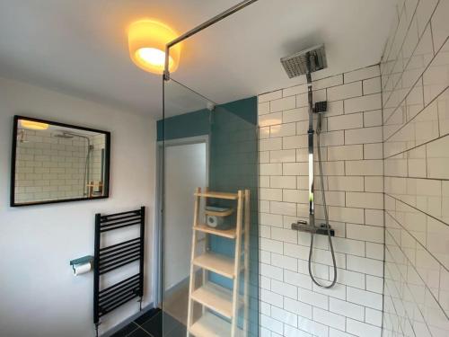 a bathroom with a shower with a glass door at Bungalow, mountain and sea views parking in Aberdyfi