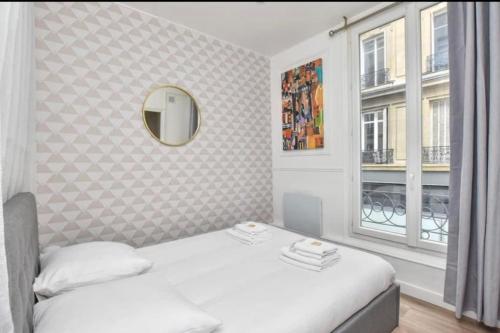 une chambre avec un lit, un miroir et une fenêtre dans l'établissement Cosy Apt. 4People - Montorgueil, à Paris