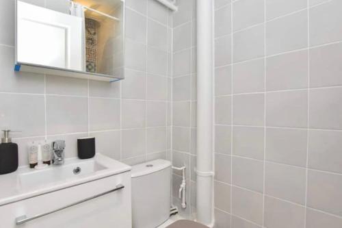 une salle de bain blanche avec des toilettes et un lavabo dans l'établissement Cosy Apt. 4People - Montorgueil, à Paris