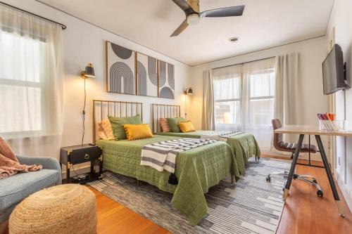 a bedroom with a green bed and a couch at Hermosa Bungalow 1920s Charm Steps to the Strand in Hermosa Beach