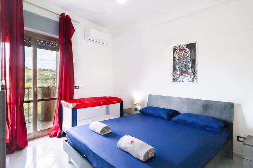 een slaapkamer met een blauw bed en een raam bij !!! 2 MIN DALLA SPIAGGIA !!! - Casa Vacanze Coralli in Sciacca