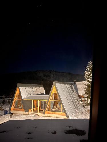 a house with a metal roof in the snow at CabanA Comandău in Comandău