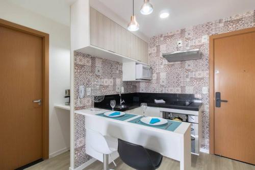 a kitchen with a white island in a room at Skyline Studio - GRU 1503 in Guarulhos