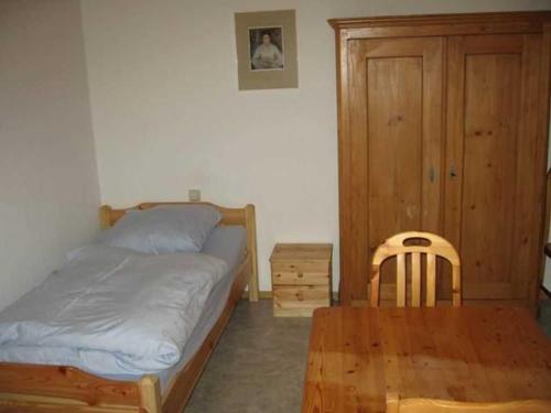 Schlafzimmer mit einem Bett und einem Holztisch in der Unterkunft Haus Sprißler in Markdorf