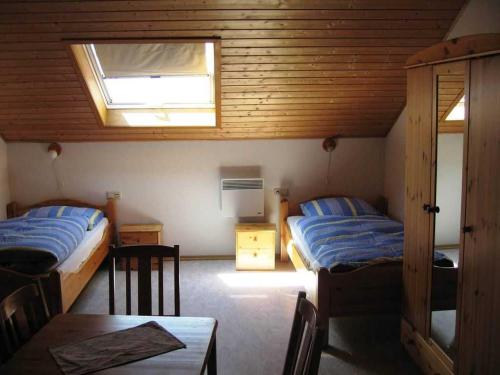 a bedroom with two beds and a table and a window at Haus Sprißler in Markdorf