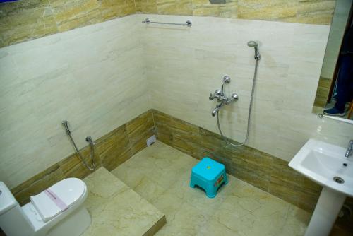 uma casa de banho com um chuveiro, um WC e um lavatório. em Hotel Anita em Baripāda