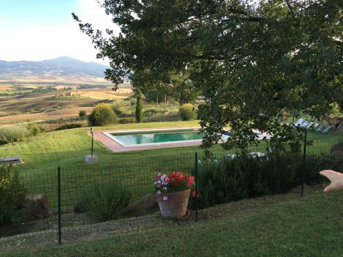 a garden with a fence and a swimming pool at Villa Fonte all'Oppio con area piscina recintata in Pienza