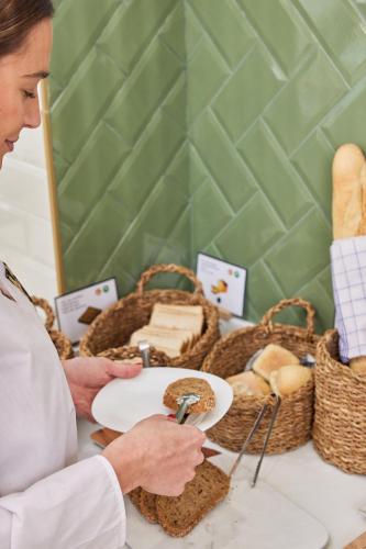 a man holding a plate with bread on a table at Venecia Plaza Centro in Valencia
