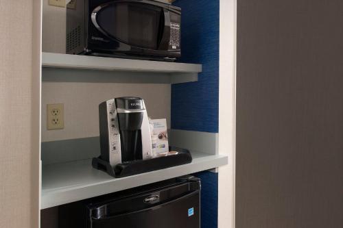 a kitchen with a microwave and a coffee maker at Holiday Inn Express & Suites by IHG Altoona by IHG in Altoona