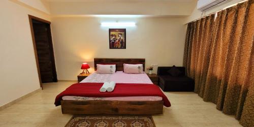 a bedroom with a bed and a chair in it at Yogvan Luxury 1BHK Apartments Tapovan Rishikesh in Rishīkesh