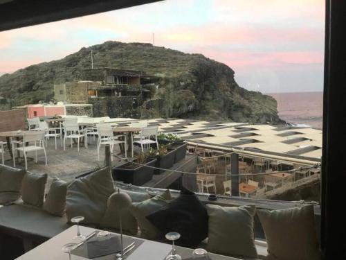 a room with a table and chairs and a mountain at Ziloto in Pantelleria