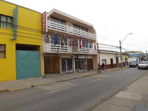 a yellow building with american flags on a street at Hotel Diaguitas Illapel in Illapel